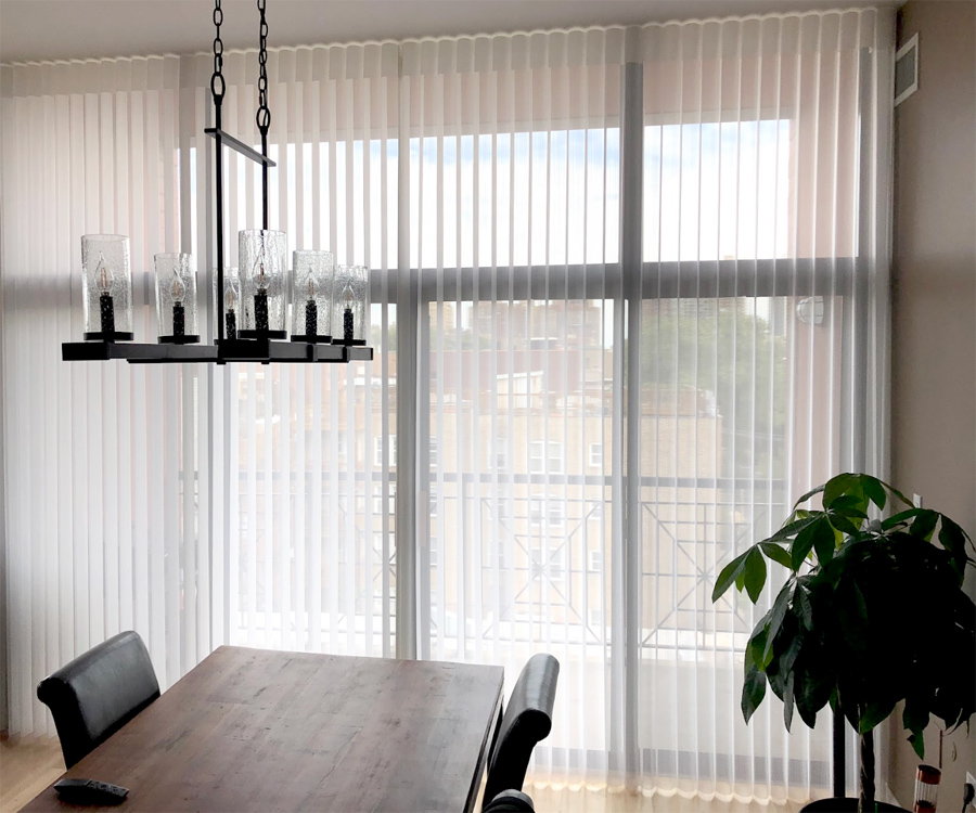 Luminette Privacy Sheers covering wide sliding glass doors in a dining room