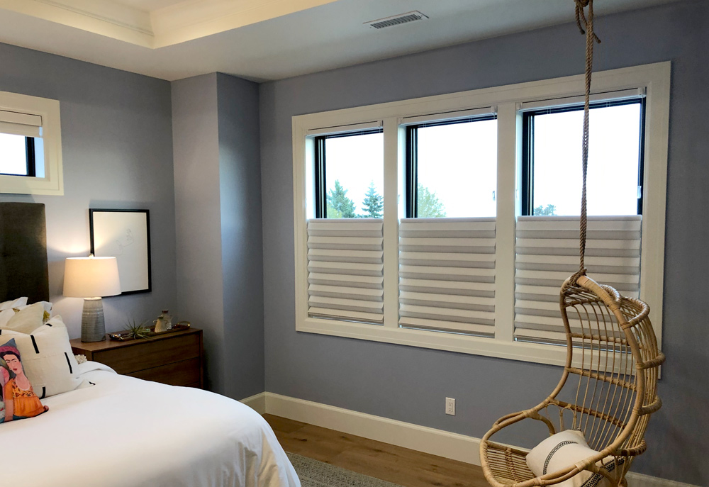 master bedroom with three windows covered with fabric roman shades in Chicago IL