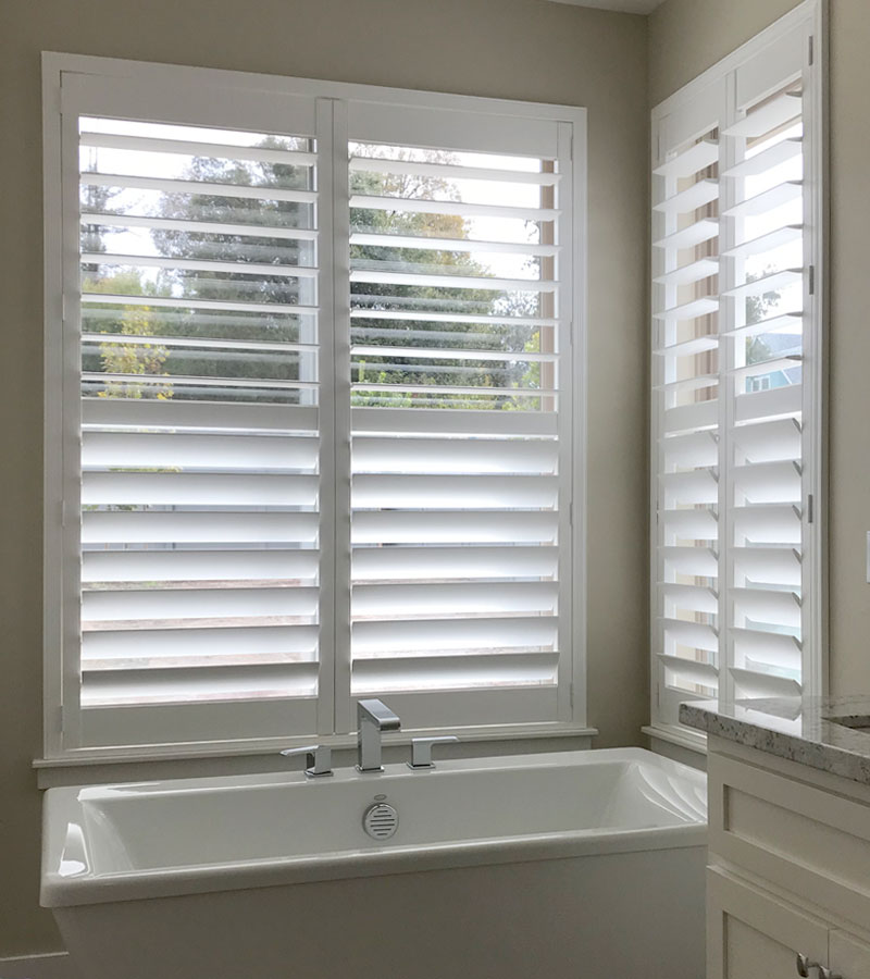 window treatments that save energy white plantation shutters in corner of bathroom in Naperville IL home