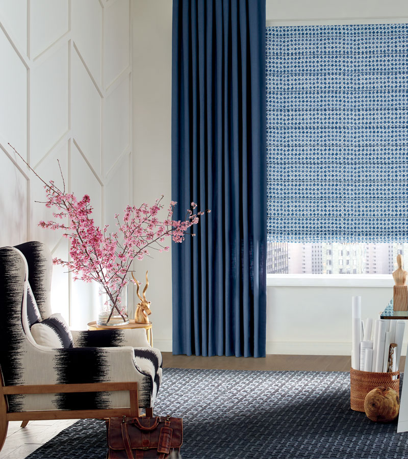 insulating window treatments with patterned blue roman shades and side draperies in Chicago 60611