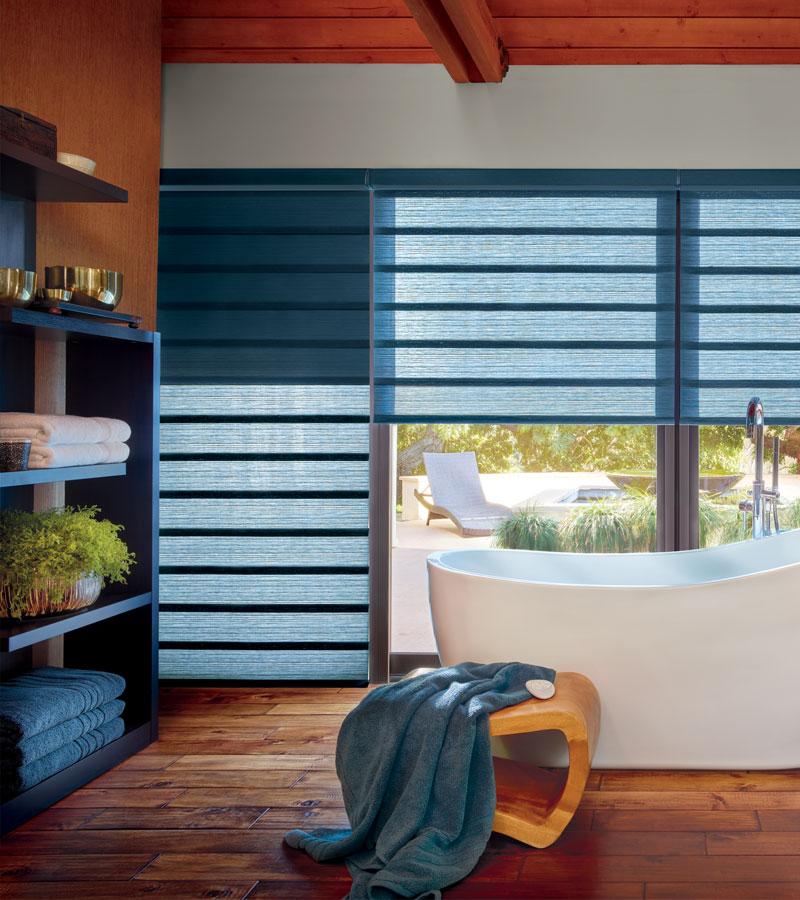 exterior wall of bathroom window with blue modern roman shades in Beaverton OR