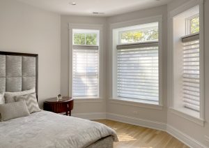 bedroom with bay window covered with sheer shades and open transom in Portland OR