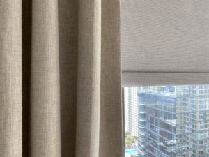 close up neutral roller shades layered with beige draperies in Chicago Gold Coast condo