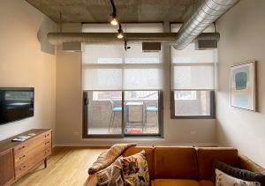 urban studio with beige roller shades on sliding doors Chicago IL