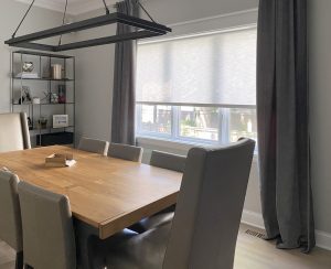 dining room with side drapery panels and light gray roller shade in Chicago IL