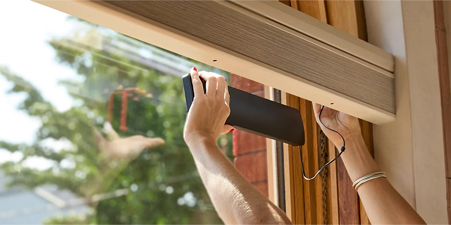 solar charger is placed in the window to charge the rechargeable battery wand for motorized shades
