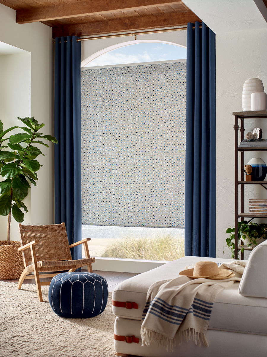 living room with arched window covered with custom roller shade and blue draperies in Chicago IL