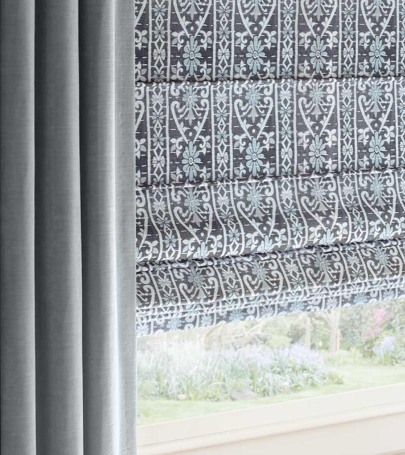 plush blue drapes framing blue and gray and white patterned roman shades winnetka, IL
