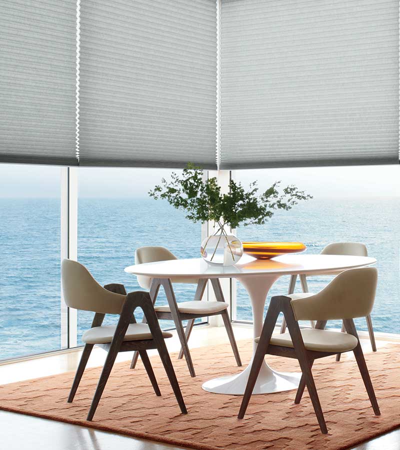 contemporary dining room table and wrap around windows and honeycomb shades