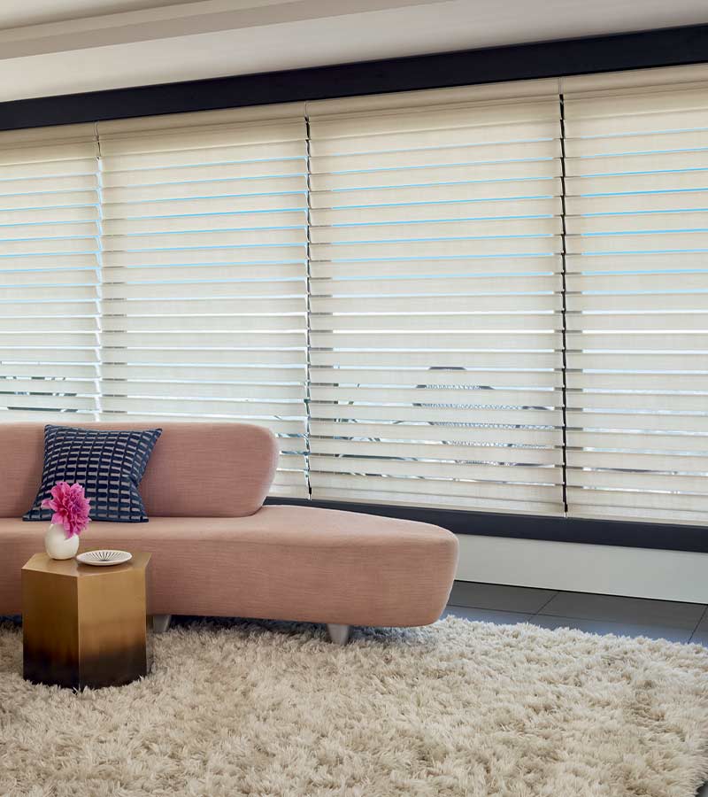 contemporary living room with pink couch and windows with large window shades