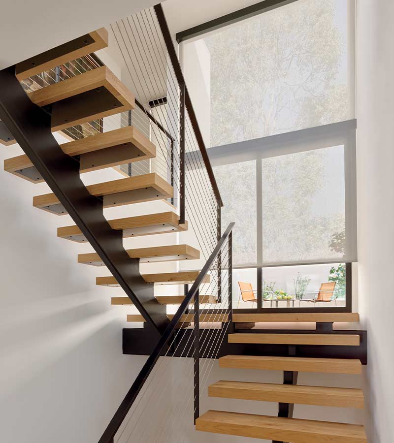 Modern floating stairs with landing overlooking backyard covered by roller shades Portland, OR