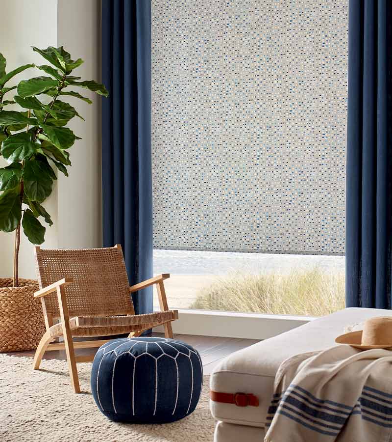 Coastal bedroom with patterned rollers with navy drapery panels