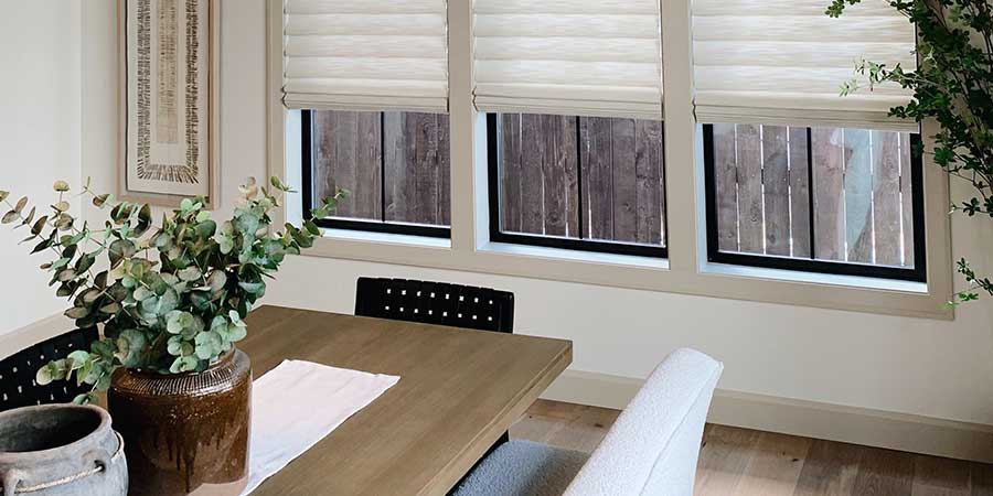 custom home with modern roman shades on black trim windows in dining room