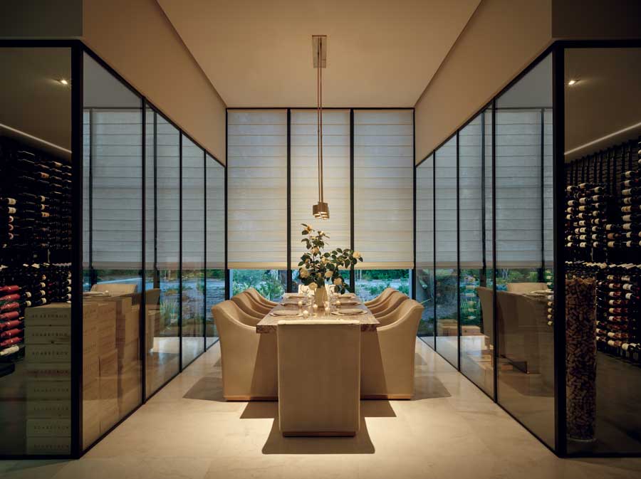 glass wine cellar with dining room table in the middle 