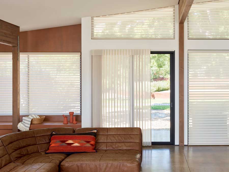 open floor plan with doors and window covered with coordinated sheer shades and vertical blinds