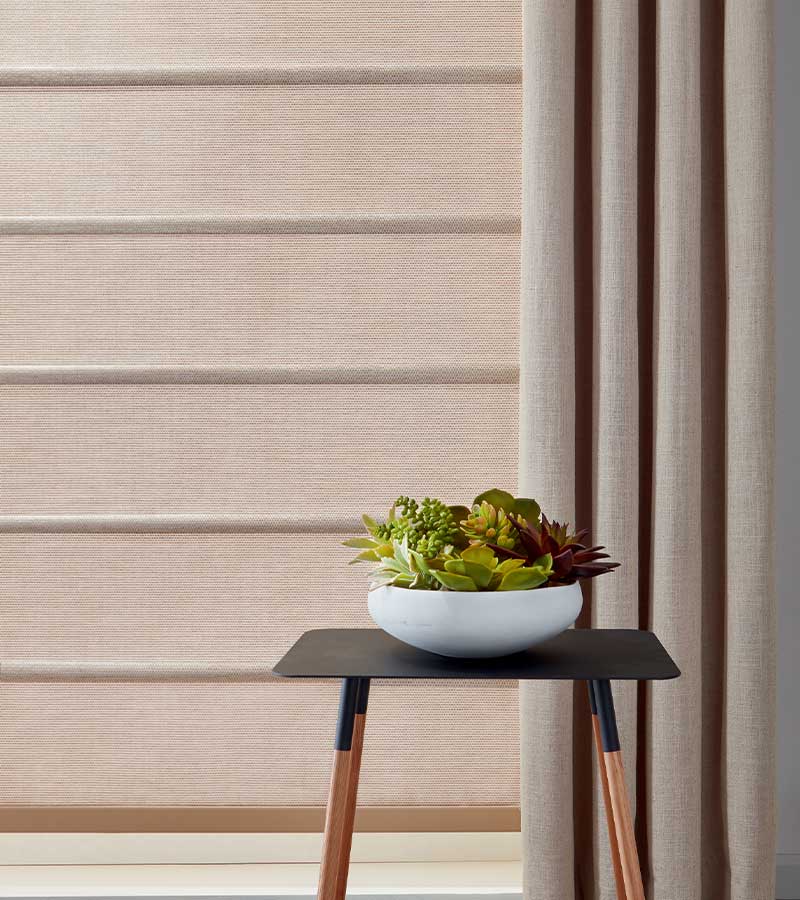 side drapery panel next to soft copper hued window shade