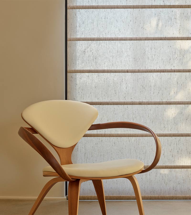 midcentury modern chair next to fabric window shades