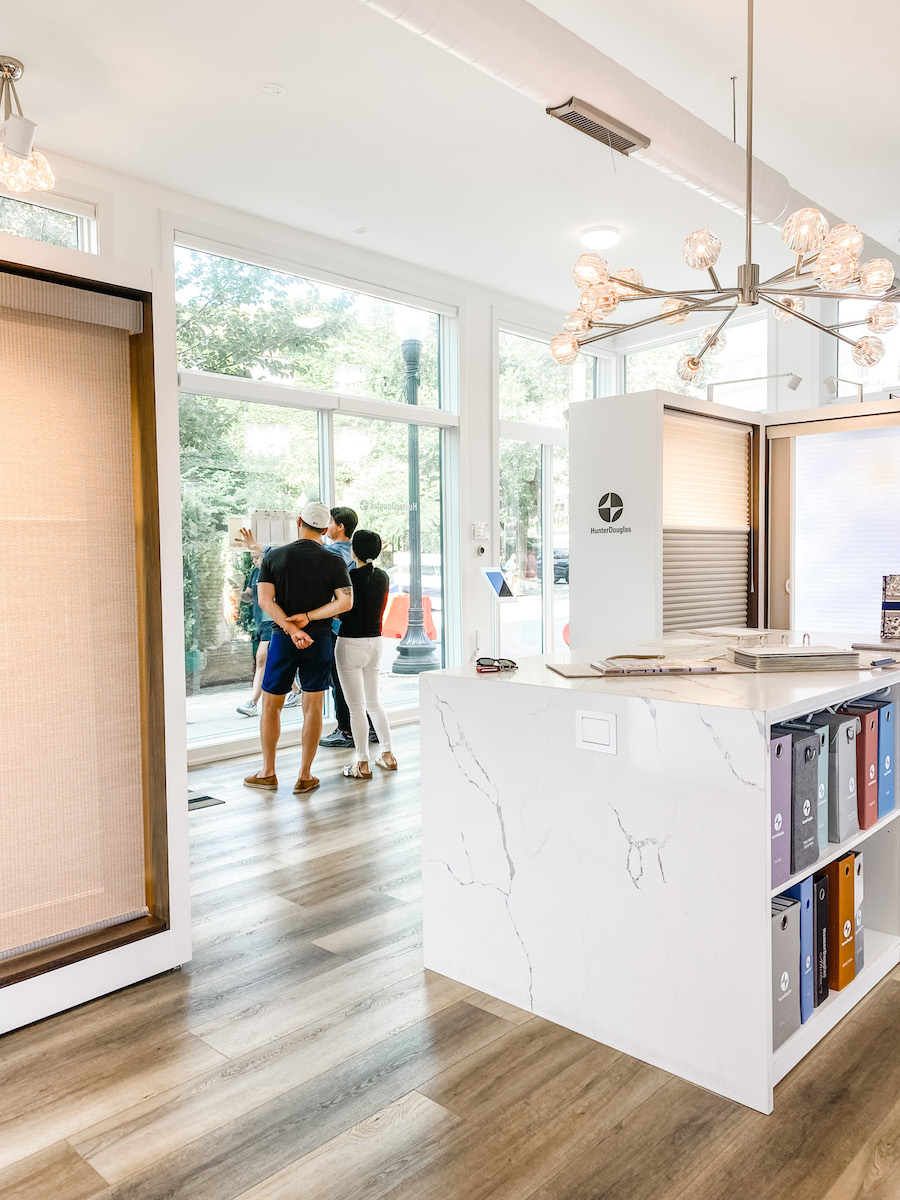 couple looks at fabrics up against glass windows