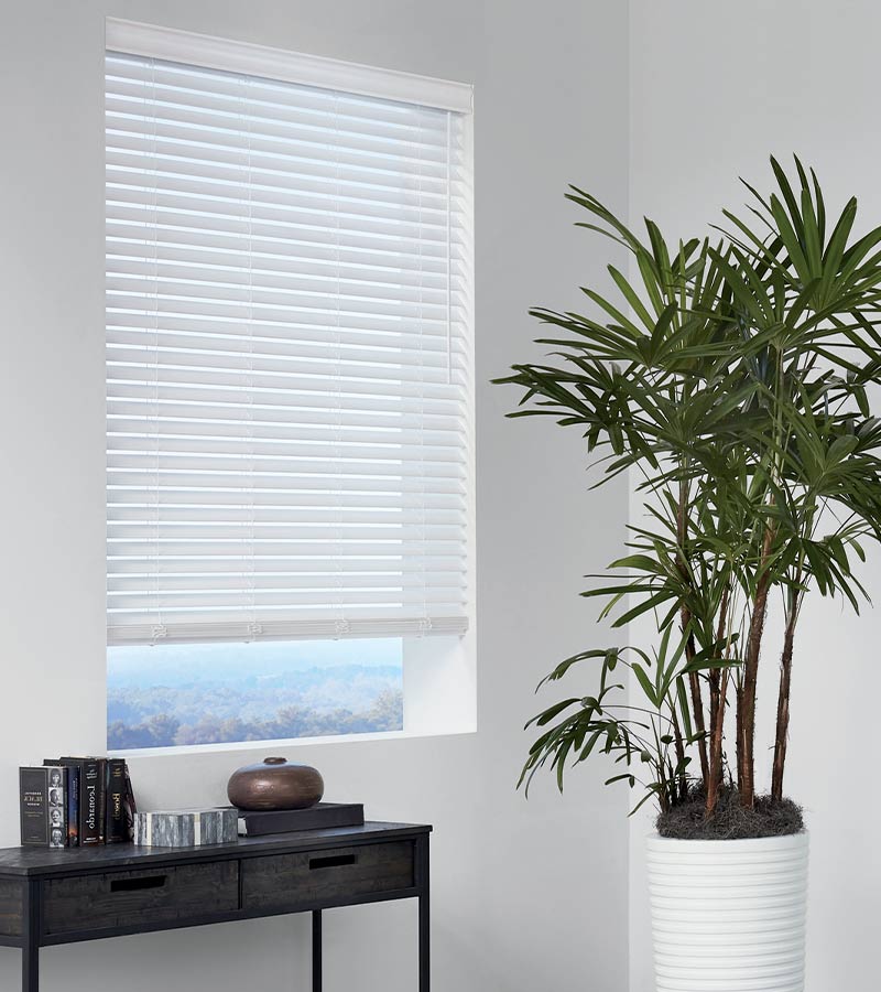 white faux blinds open slightly to see the outdoors