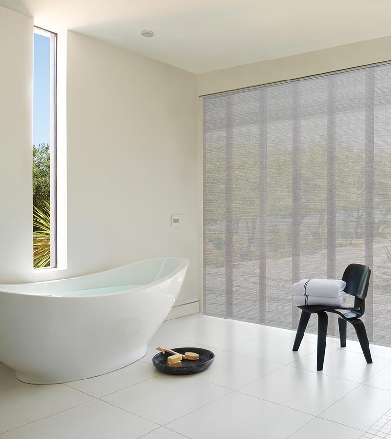 Vacation resort bathroom with floor to ceiling vertical shades in gray for privacy and comfort