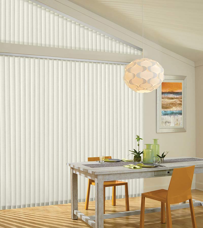 dining room large angled windows and sheer vertical blinds