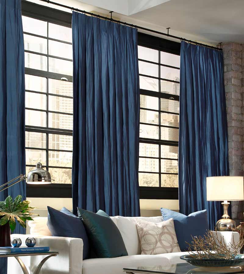 dark blue fabric drapery panels on black trim windows