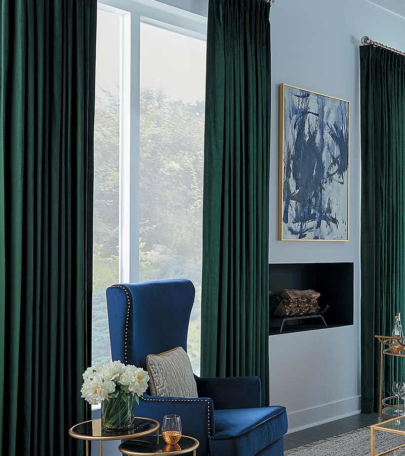 dark green drapery fireplace blue chair and wall painting