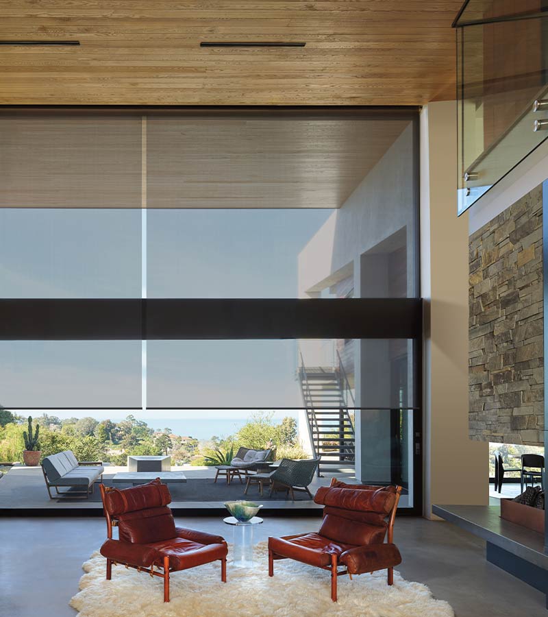 opaque roller shades on large window facing outdoor patio space with chairs