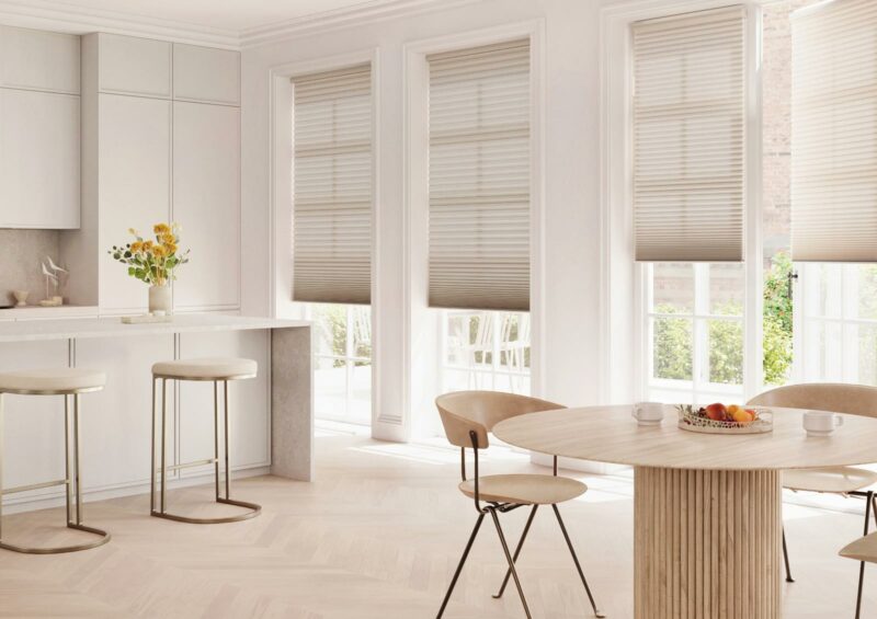 White kitchen with honeycomb shades on windows in Winnetka