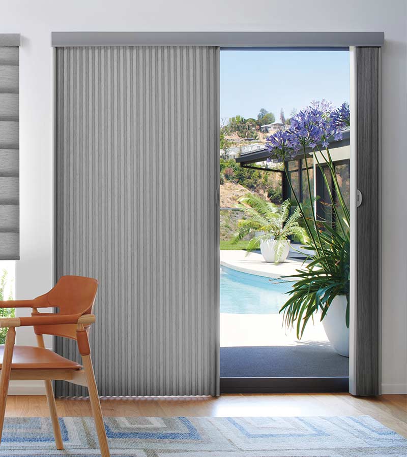 glass patio door leading to pool area covered by a vertical cellular shade in gray fabric