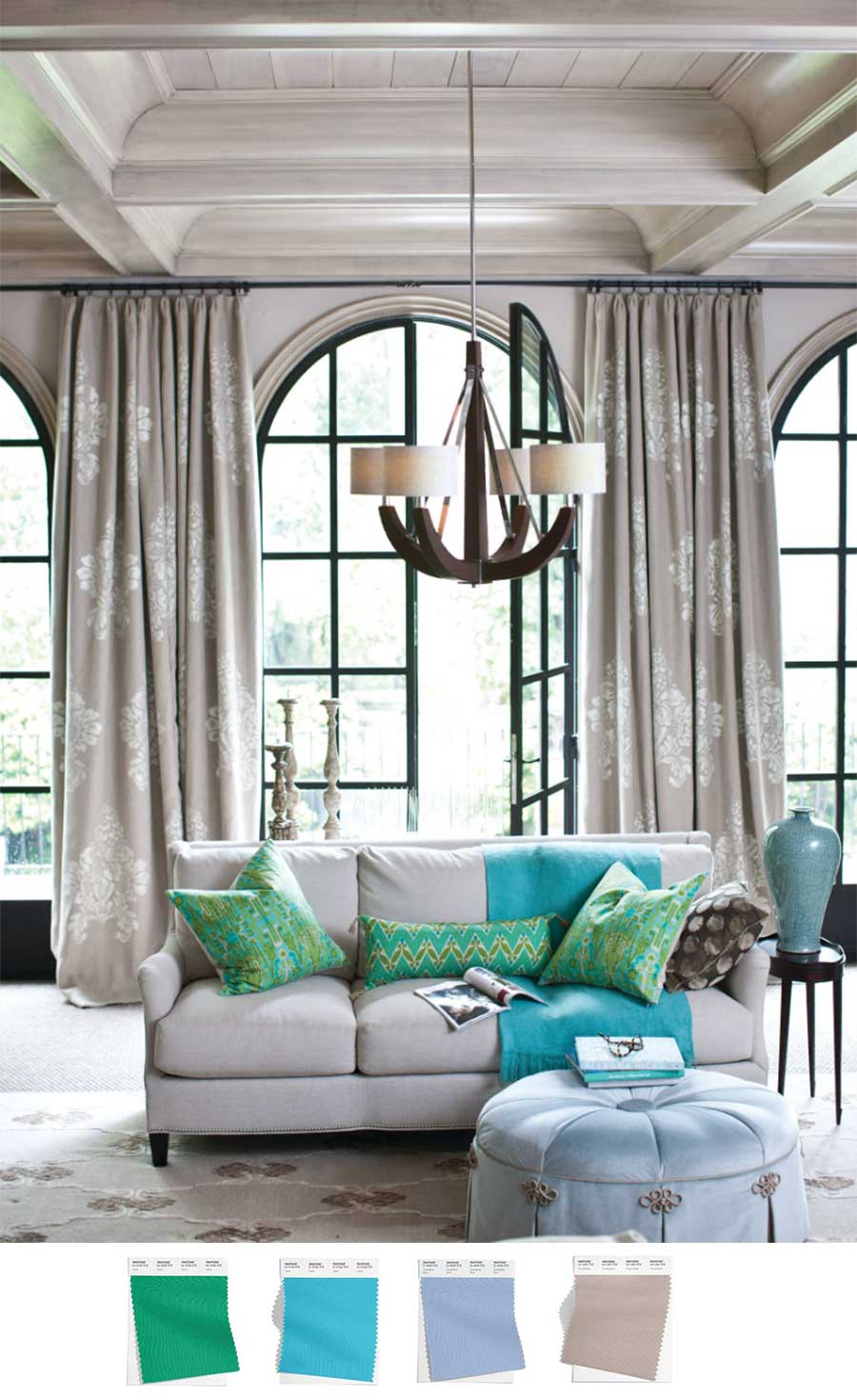 living room with arched windows high ceilings and floor to ceiling drapes with accents in the latest color trends