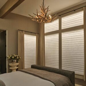 bedroom with large window coverings glowing with interior backlighting