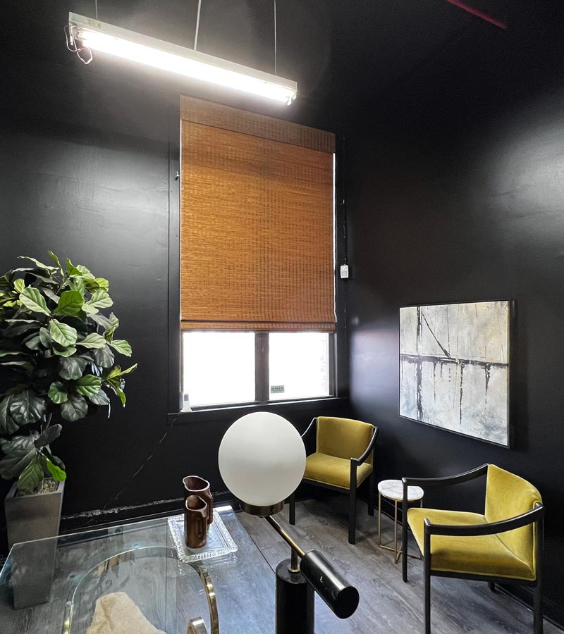 bowery & bash black sitting room with provenance woven wood shades