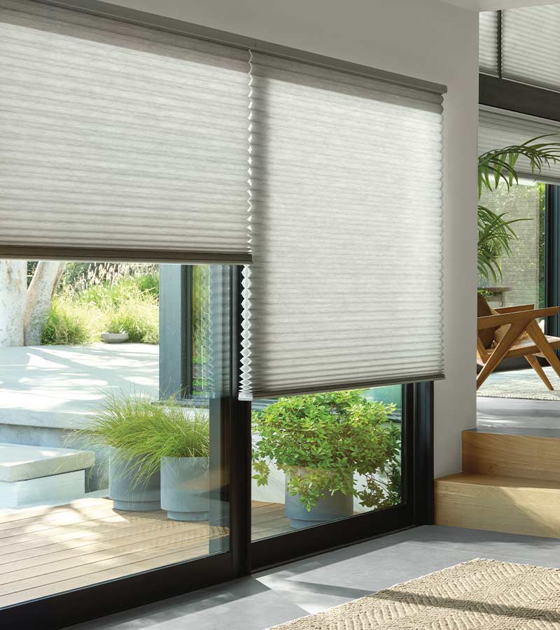 gray fabric cellular honeycomb shades on framed black windows