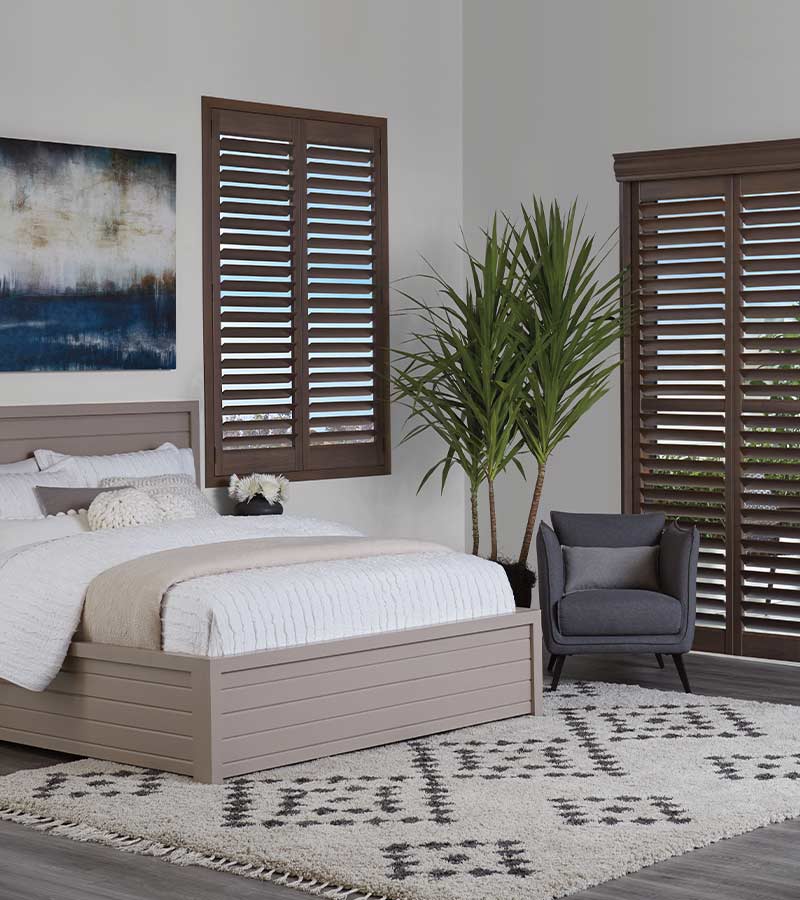 guest bedroom brown shutters and coastal setting