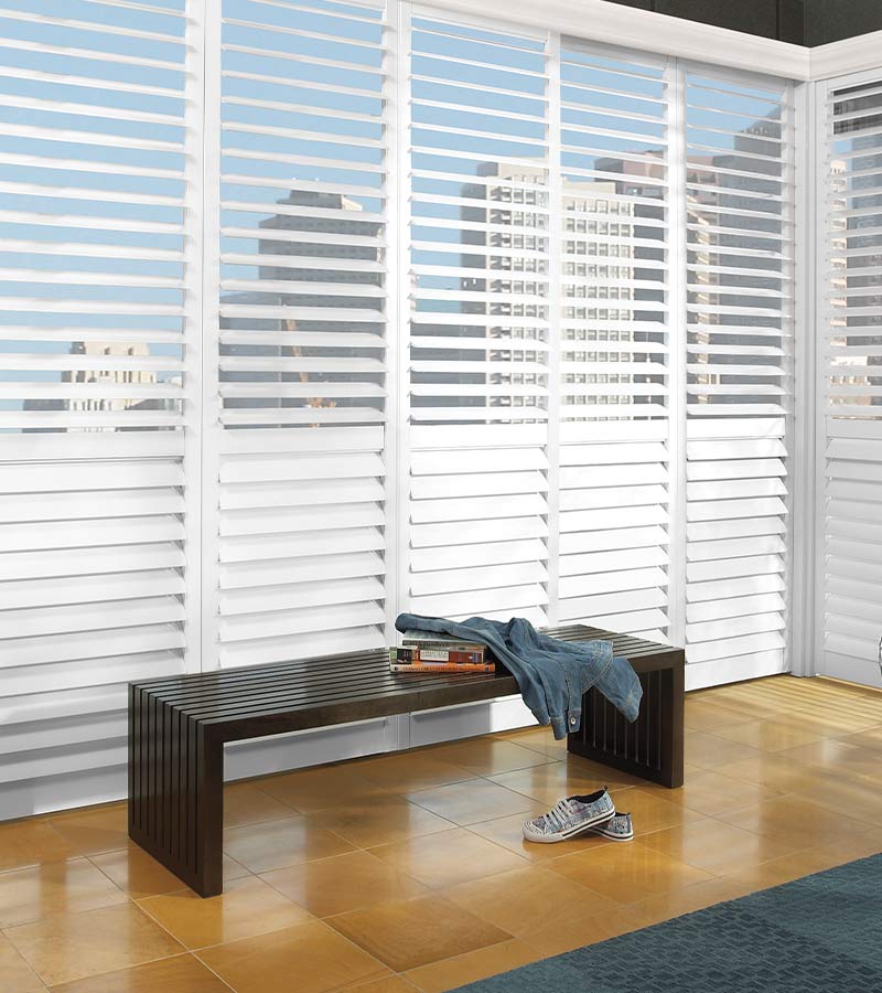 floor to ceiling white plantation shutters overlooking city skyline