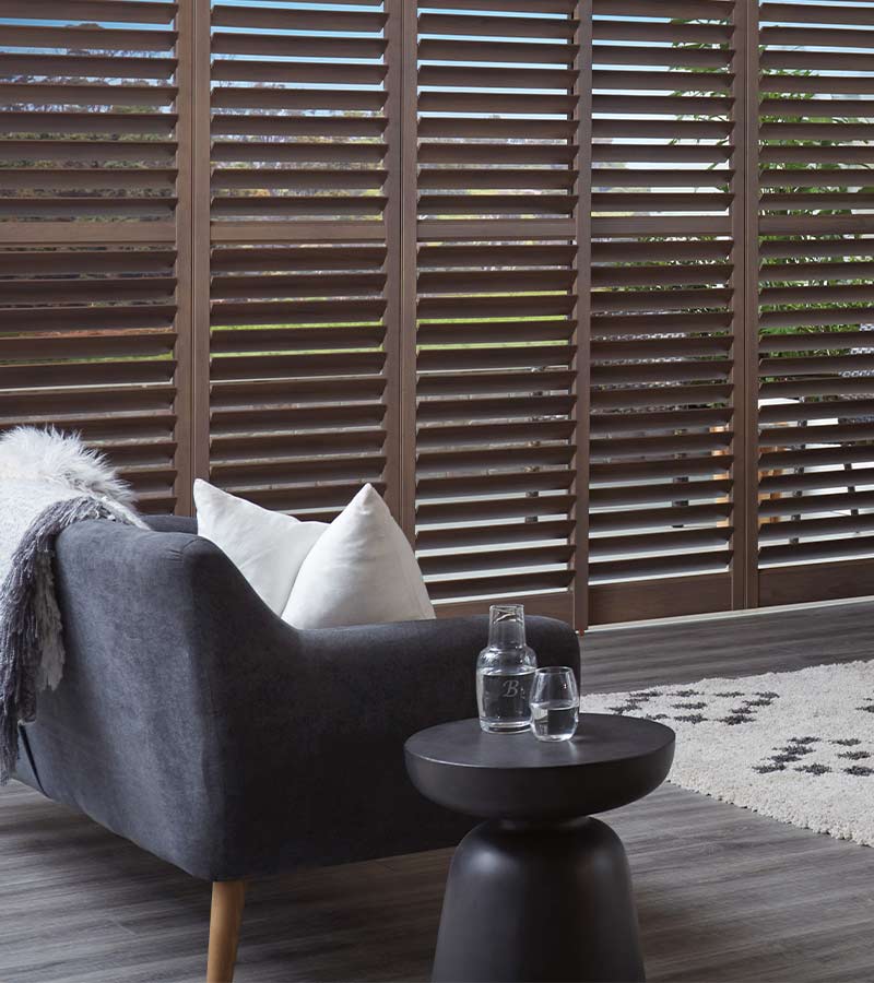 brown interior shutters on large window on sliding glass door