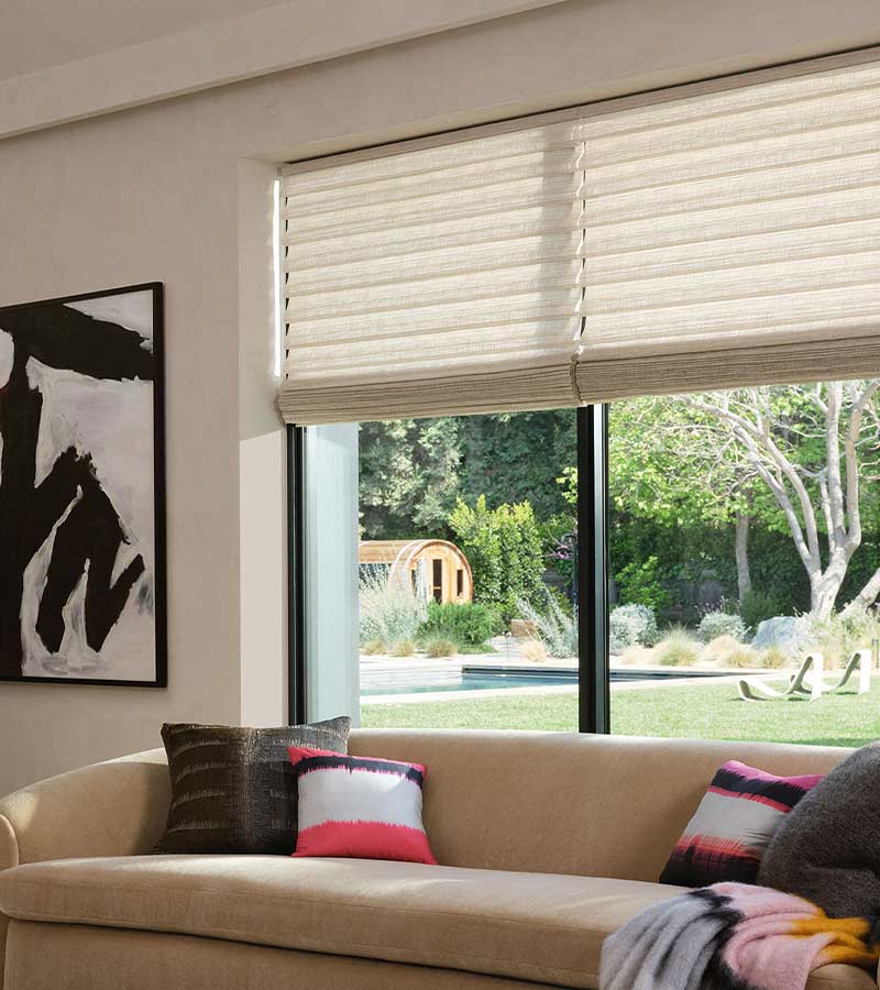 stacked roller shades on black trim windows in fun living room with pops of color