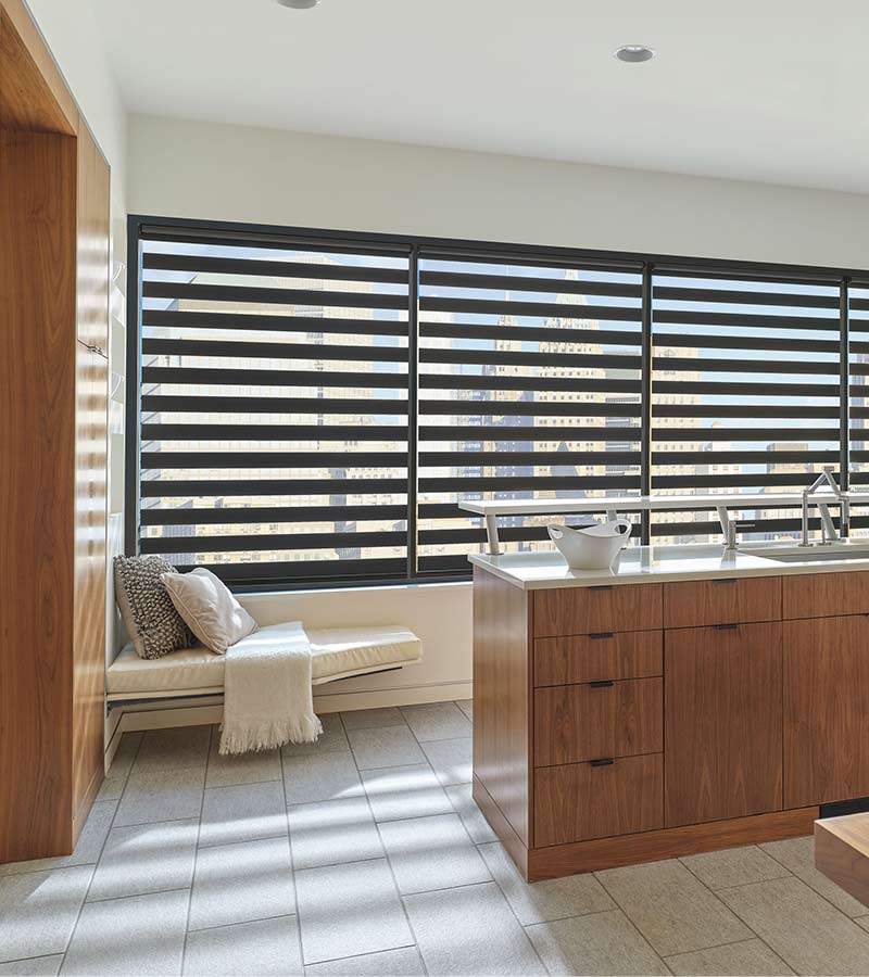 kitchen seating area overlooking landscape view of the outdoors with banded zebra shades