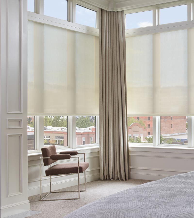 designer roller shades and floor to ceiling drapery