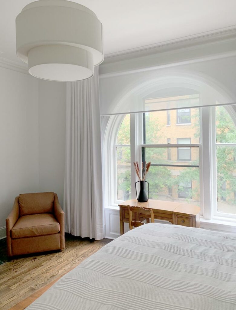 custom drapery and designer roller shades in bright bedroom