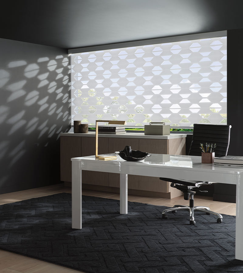 Hunter Douglas banded shades cover large window with geometric shaped fabric for feature wall in home office