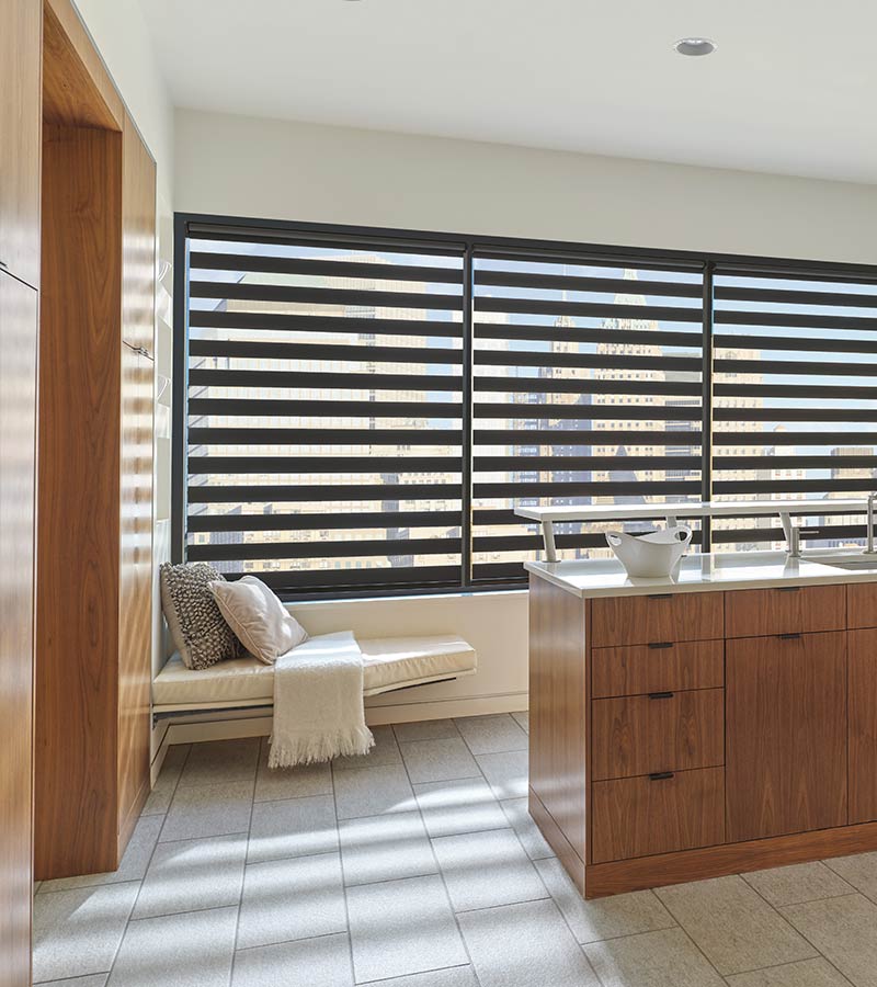 Zebra window blinds cover wall of windows in to rotate fabric layers in kitchen