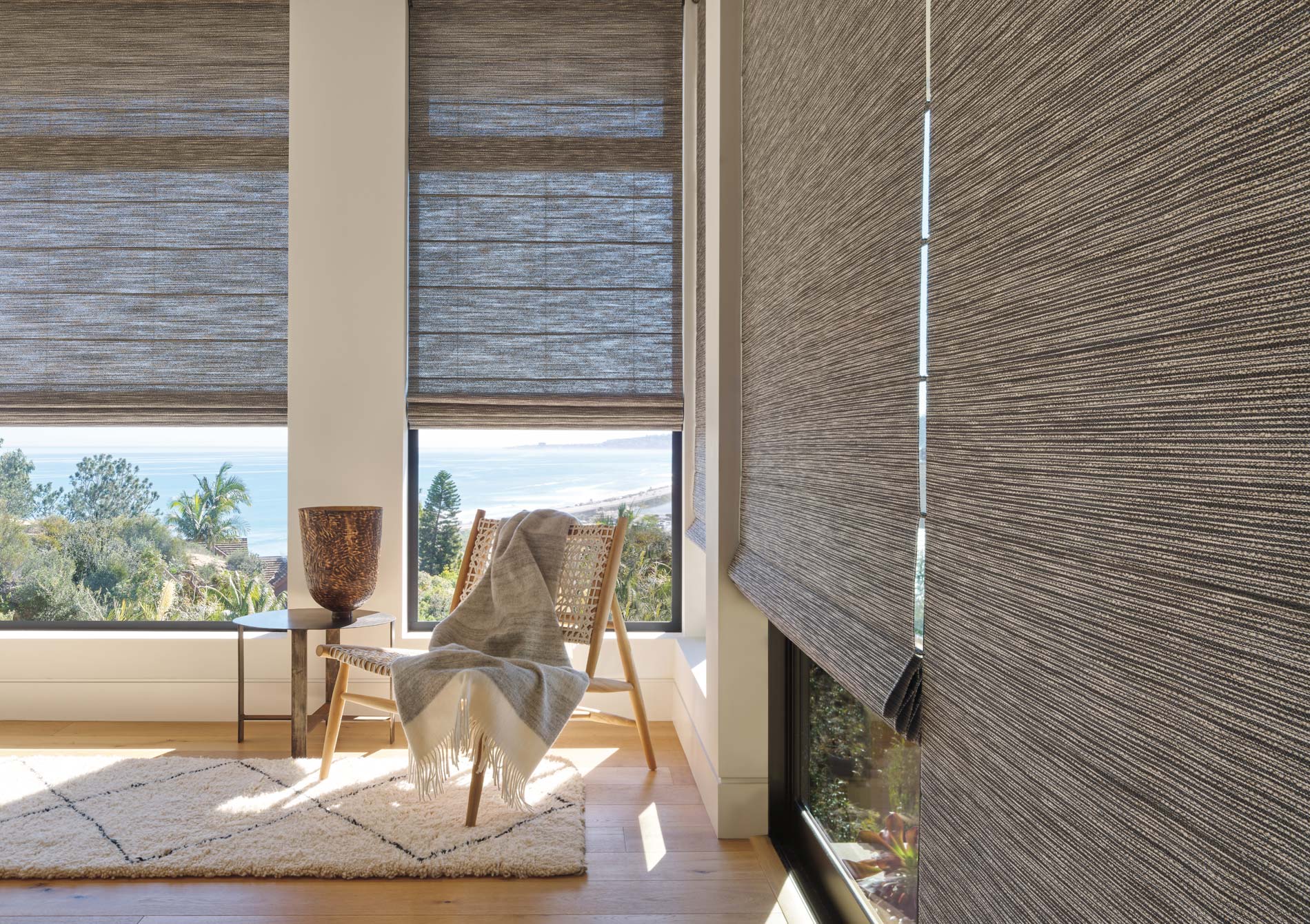 Textured Roman shades on large sitting room windows with soft natural light