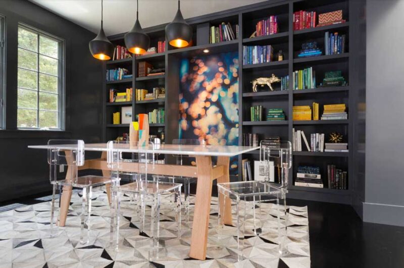 dining room with black built in bookshelves, highlighted with a range of colorful books