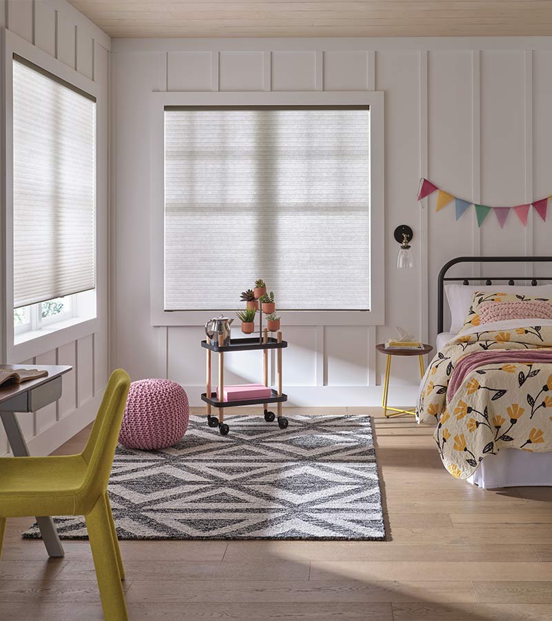 children bedroom with white honeycomb cellular window shades and colorful bedding