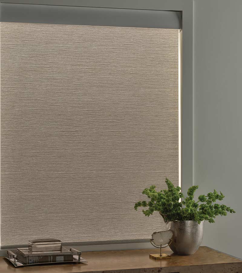 aura illuminated designer roller shade in bedroom