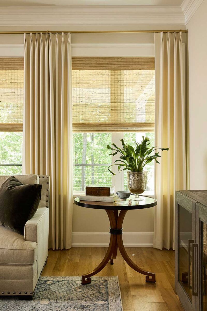 double pinch pleat drapery layered with woven wood shades in living room