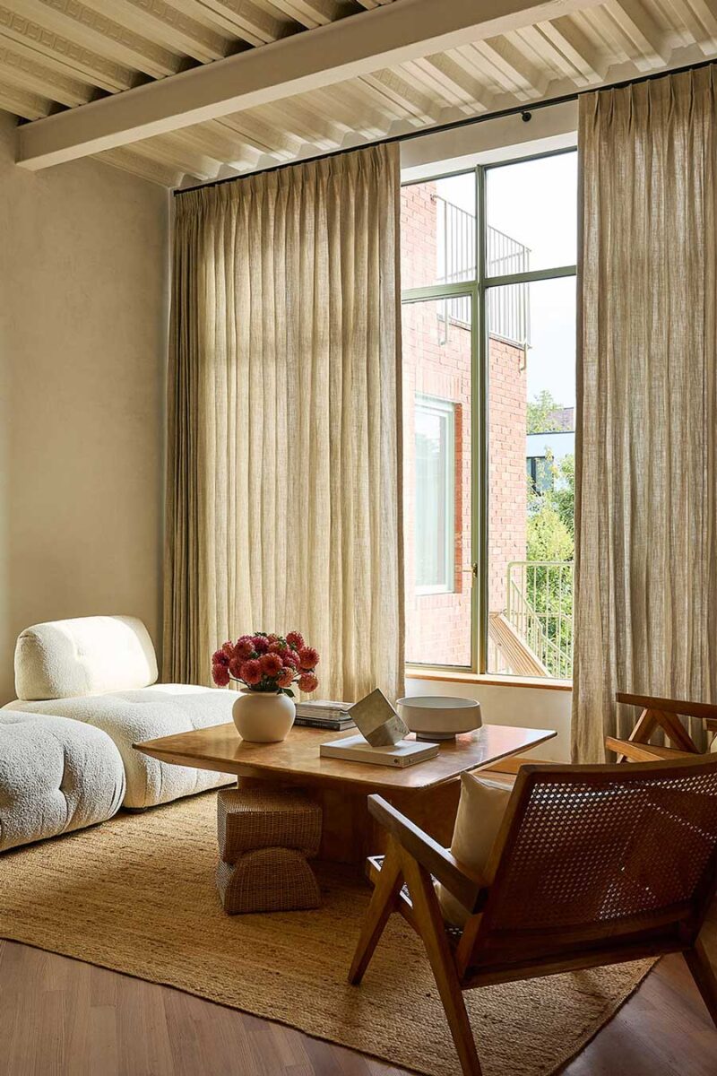 inverted pleat draperies for light-filtering on floor-to-ceiling windows in modern living room with low profile design