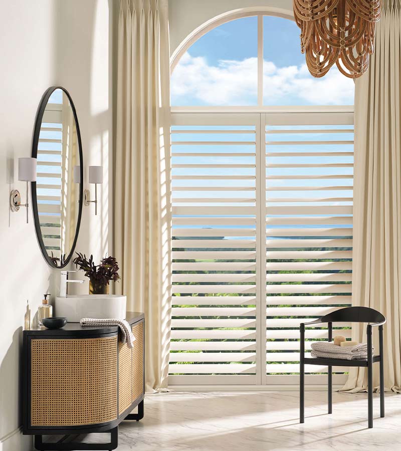 Bathroom with Palm Beach™ PolySatin™ shutters and custom drapery